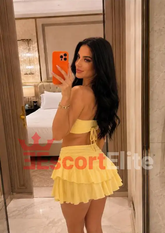 Alessia Wien gelbes Sommeroutfit Hotelspiegel Alessia Premium Escort Wien in gelbem Sommeroutfit mit Rüschenrock – Spiegelselfie im Luxushotel