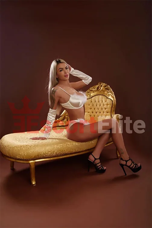 Escort Lola Viena en lencería blanca sobre sofá dorado