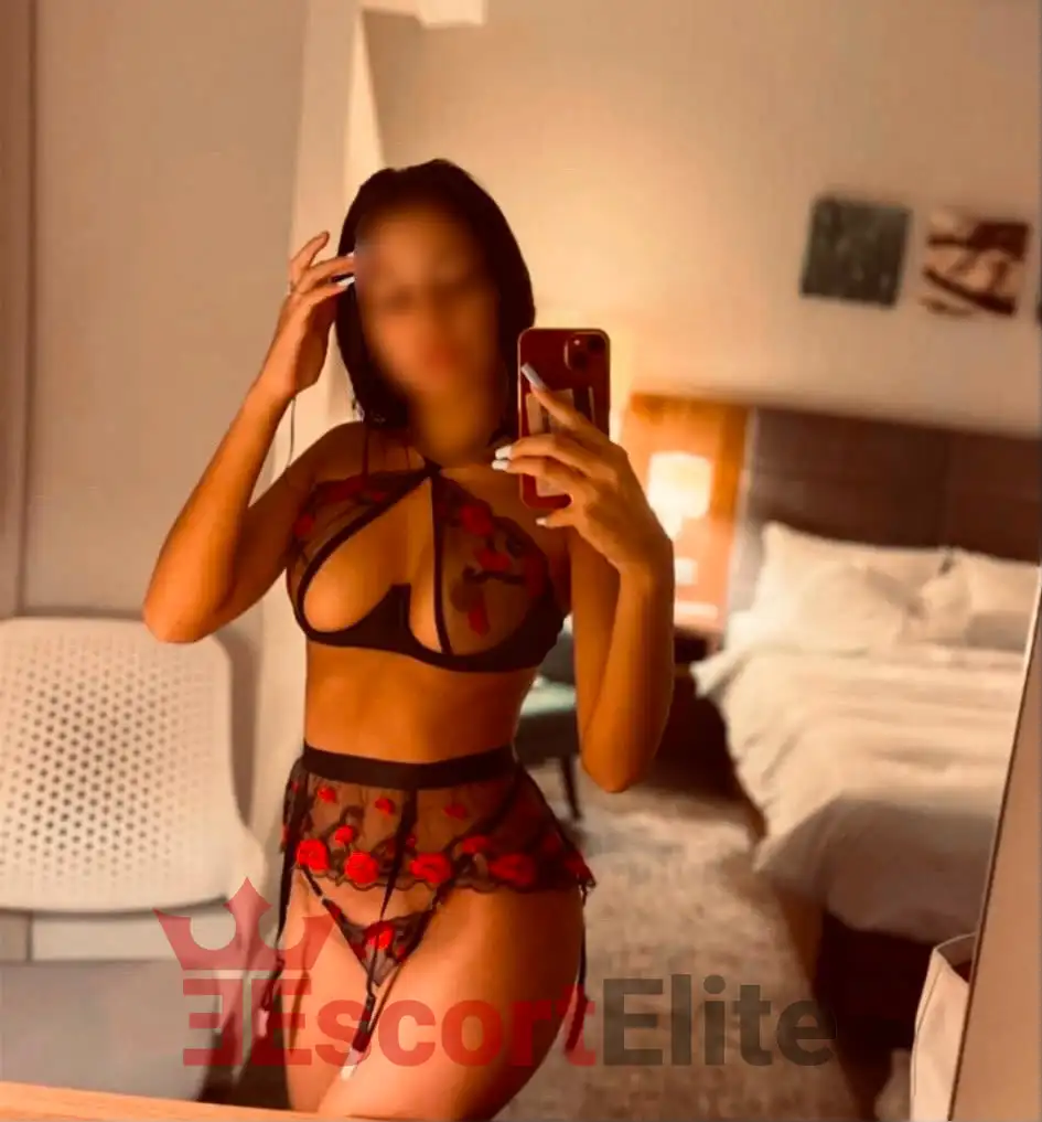 Mely Viena – Lencería de encaje floral en el hotel Joven escort Mely Viena en lencería de encaje negro con bordado floral rojo en una cálida habitación de hotel